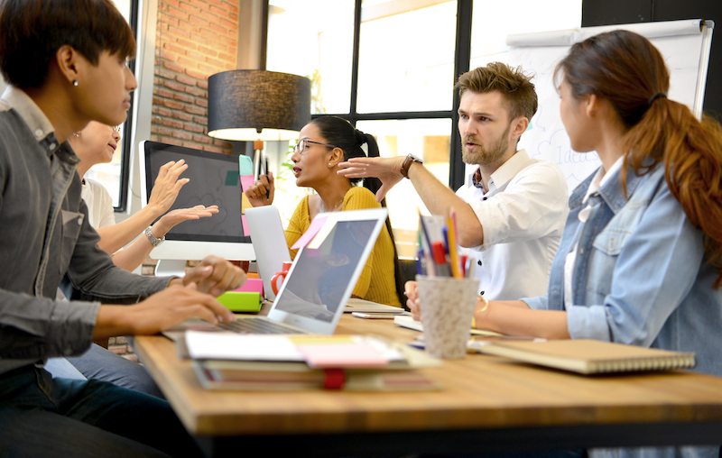 Team of people discussing around table